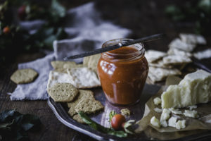 En bricka med ost, nyponsmör, och kex.