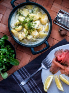 Stuvad potatis med gravad lax med färskt grönt.