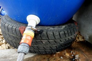 En koppling i nedre delen av en vattentunna.