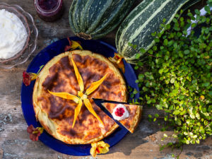 Vacker squashkaka tillsammans med grädde, sylt och två stora squashar.