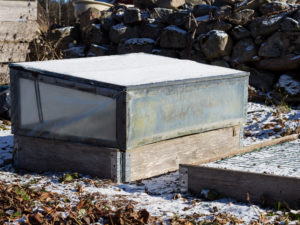 En pallkrage med drivhus och lock över.