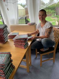 Sara skrattar in i kameran medan hon signerar.