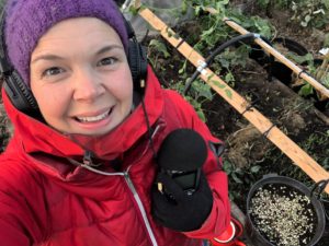 Sara in red clothes with headphones and a microphone.