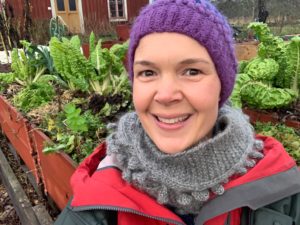 En glad Sara i sin köksträdgård