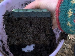 Undersidan på redskapet med jord på.