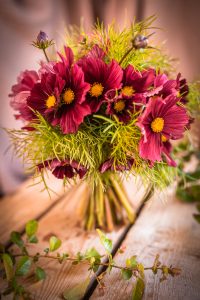 Bukett med rosa blommor och gröna blad.