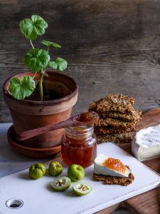 En ostbricka med kex och marmelad.