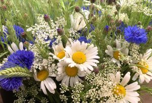 Närbild på blombukett i blå, vita och gula nyanser.
