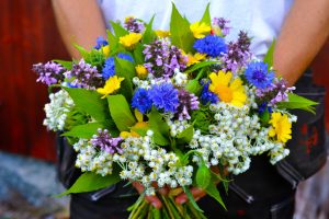 En man håller en bukett framför sig.