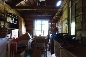 Ett litet rum, öppet till nock i tak, helt fyllt av kartonger och prylar.