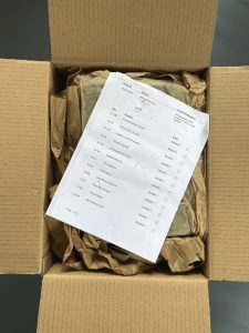 En kartong med grejer inuti, locket öppet.